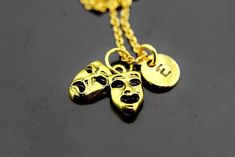 "Gold Comedy Necklace, Tragedy Masks Charm Necklace, Theatrical Mask Necklace, Theater Drama Mask Jewelry, Personalized Gift HOW TO ORDER 1) Select the quantity 2) Select stamp the initial 3) Add to cart DESCRIPTION ♥ High Quality Real 18K Gold Plated over stainless steel/brass chain 45 cm or about 17.7 inches ♥ High Quality Real 18K Gold Plated over stainless steel/brass 8- 10 mm. ♥ Gold Plated Alloy Pendants, approx: 15x10mm. (5/8\" x 3/8\") ** Conversion: 1 inch = 25.4 mm or 1 mm = 0.0393 inc Themed Gold Jewelry For Party, Theatrical Mask, Drama Masks, Tragedy Mask, Stethoscope Necklaces, Medical Student Gift, Mask Necklace, Jewelry Personalized, Etsy Personalized Gifts