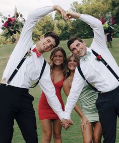 four people in formal wear are posing for a photo with their arms around each other