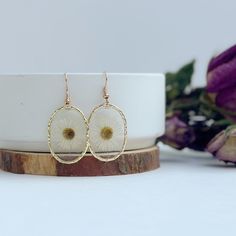 This listing is for one pair of small white Needle Chrysanthemum resin earrings in small oval shaped frames. These white Needle Chrysanthemum earrings are light weight, hand poured, carefully crafted and uniquely designed! Created with real dried flowers, these earrings are a perfect gift for a friend, girlfriend, wife, fiancé or even for yourself!   -All of our earrings use NICKEL FREE AND LEAD FREE HYPOALLERGENIC HOOKS.   Every earring is hand crafted and so each are unique! CHECK OUT OTHER BEAUTIFUL OPTIONS FROM OUR CHRYSANTHEMUM COLLECTION -Tear dropped shaped Needle Chrysanthemum Earrings: https://www.etsy.com/listing/1485295330 -Heart shaped Needle Chrysanthemum Earrings: https://www.etsy.com/listing/1485270786 -Circle Shaped Needle Chrysanthemum Earrings: https://www.etsy.com/listin Elegant Resin Flower Earrings, Resin Pressed Flower Drop Earrings, Pressed Flower Resin Drop Earrings, Unique Flower-shaped Resin Earrings, Flower-shaped Resin Earrings With Pressed Flowers, Circle Shape, Pressed Flowers, Flower Earrings, Resin Art