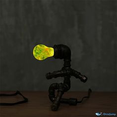 a small tripod with a yellow light on it's head sitting on a table