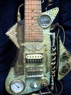 an old fashioned guitar made out of metal parts and other things that are attached to it