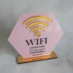 a pink and gold plaque with wifi on it's side, in front of a white background