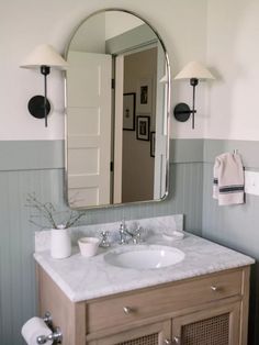 a bathroom sink with a mirror above it and two lights on the wall next to it