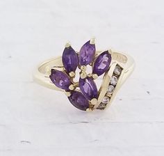 Vintage Amethyst & Diamond ring. Details: Size: US 5 ( can be sized ) Weight: 3.2 grams Primary stone: Amethyst Shape: Marquise ( 6 stones in total ) Secondary Stone: Diamond Shape: Round Metal: 14k Yellow Gold Condition: Previously worn/great condition Inside of band is stamped and tested for '14k' gold. All pieces are polished and refinished in our shop. SIZING: Currently this ring is a size 5 but could be sized up or down for an additional small fee if desired by adding custom ring sizing Amethyst And Diamond Ring, Custom Ring, Amethyst Jewelry, Multi Stone Ring, Diamond Shape, Multi Stone, Custom Rings, Stone Rings, Diamond Shapes