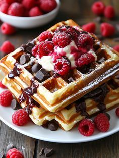 waffles topped with raspberries and chocolate sauce