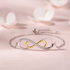 A brilliant way to show her your love is forever, this dainty bracelet will certainly touch her heart. Crafted in sterling silver, this bracelet features a sparking infinity symbol and a gold tone infinity symbol. This elegant bracelet makes a stunning statement of everlasting love. A great anytime choice, this fashion bracelet is sure to become an instant favorite.Carat Weight: 1.95 ctStone Size: 1.5 mmNumber of Stones: 26 Stone Shape: RoundStone Color: Diamond WhiteWeight: 4.2 gWidth: 42.4 mmH Cubic Zirconia Infinity Jewelry For Mother's Day, Elegant Sterling Silver Jewelry For Friendship, Silver Infinity Diamond Bracelet For Anniversary, Elegant Infinity Jewelry For Friendship, Elegant White Gold Friendship Bracelets, Elegant Rose Gold Infinity Bracelet, Sterling Silver Infinity Bracelets For Anniversary, Sterling Silver Infinity Bracelet For Anniversary, Sterling Silver Infinity Bracelet With Adjustable Chain