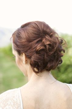 a woman with red hair is wearing a white dress and has her back turned to the camera