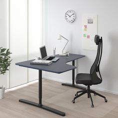 a desk with a chair and a clock on the wall