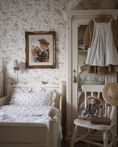 an old fashioned bedroom with floral wallpaper and white furniture, including a small bed