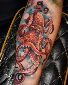 an octopus tattoo on the leg of a man with watercolor paints and inks