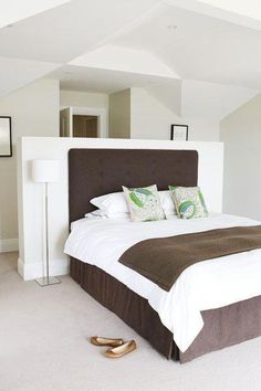 a bedroom with white walls and carpeted flooring has a large bed in it