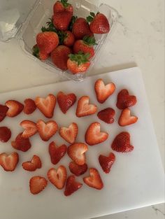 strawberries are cut up and placed on a cutting board