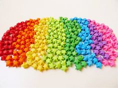 many different colors of bows are arranged in a rainbow - hued pattern on a white background