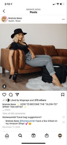 a woman sitting on top of a brown couch next to a black bag and wearing a hat