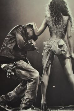 a man kneeling down next to a woman on stage