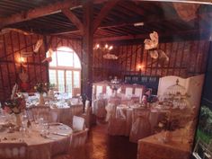 a room filled with tables and chairs covered in white linens