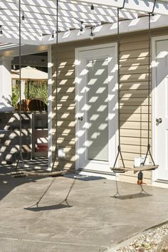 the outside of a building with two swings and an awning over it's door