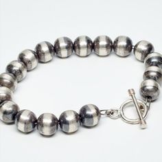 This elegant and classy oxidized bracelet is perfect on its own or to complement its matching beaded necklaces.  The beads are 8MM in diameter and are threaded on double stainless steel chain, which makes a stronger bracelet.  

All our beads are of a thicker gauge so that they keep their shape, not just when you first buy them, but for years to come.

This bracelet measures 7.5" long and has a T toggle closure that is both secure and very easy to put on and off. Matching Beaded Necklaces, Silver Beaded Bracelet, Oxidized Silver, Beaded Necklaces, Steel Chain