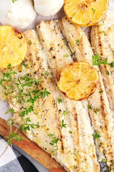 grilled fish with lemons and garlic on a cutting board