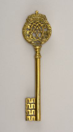 an antique gold key with ornate designs on it