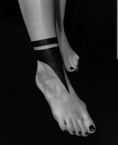 black and white photograph of woman's bare feet with striped stockings on her ankles