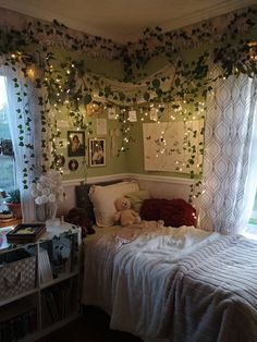 a bedroom decorated for christmas with lights and greenery on the wall above the bed