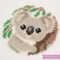 a cross stitch koala with leaves on it's head