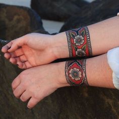 two people with matching wristbands sitting on rocks