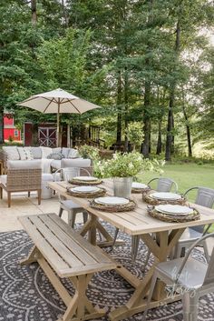 an outdoor table and chairs set up on a rug in front of a patio area