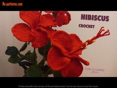 a red crocheted flower is in front of a white sign that says hibiscus crochet