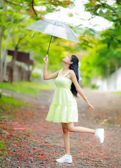 a woman in a yellow dress holding an umbrella