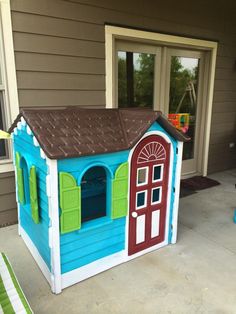 a toy house made out of cardboard sitting on the front porch