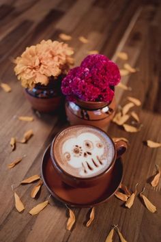 a cappuccino in a brown cup with sugar skulls on the foam and flowers