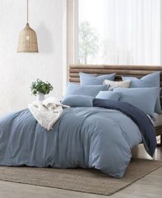 a bed with blue sheets and pillows in a room