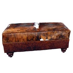 a brown and white cowhide covered ottoman