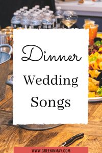 a dinner table with a sign that says dinner wedding songs on it and food in the background