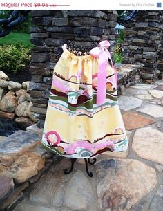 a bag sitting on top of a metal stand next to a stone wall and grass