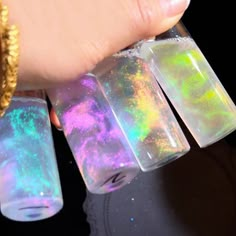 a person is holding some holographics in their hand and wearing a gold bracelet