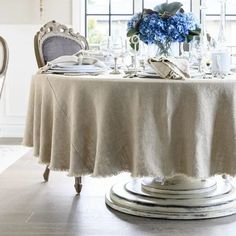 the table is set with blue flowers and place settings