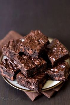 chocolate brownies stacked on top of each other on a plate with napkins around them