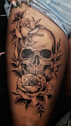 a woman's thigh with a skull and roses on it