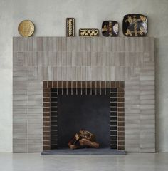 a fire place in a living room with decorative items on the mantle