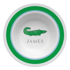 a green and white bowl with a crocodile on the side that says james's