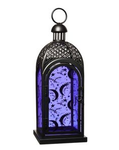 an ornate lantern is lit up with purple light and black metal accents, on a white background