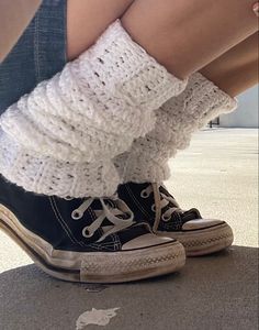 the legs and ankles of a person wearing converse shoes with socks on them, sitting down