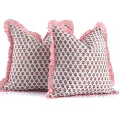 two pillows with ruffled edges and pink trims on them, sitting side by side