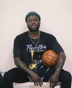 a man sitting on a bench holding a basketball