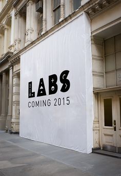 a large white sign on the side of a building that says labs coming 2013 in black