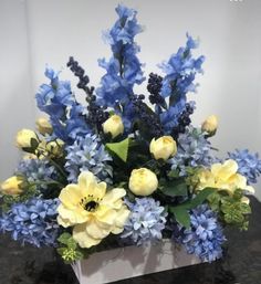 a vase filled with blue and yellow flowers