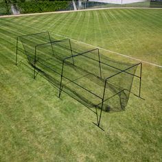 a baseball cage sitting on top of a lush green field